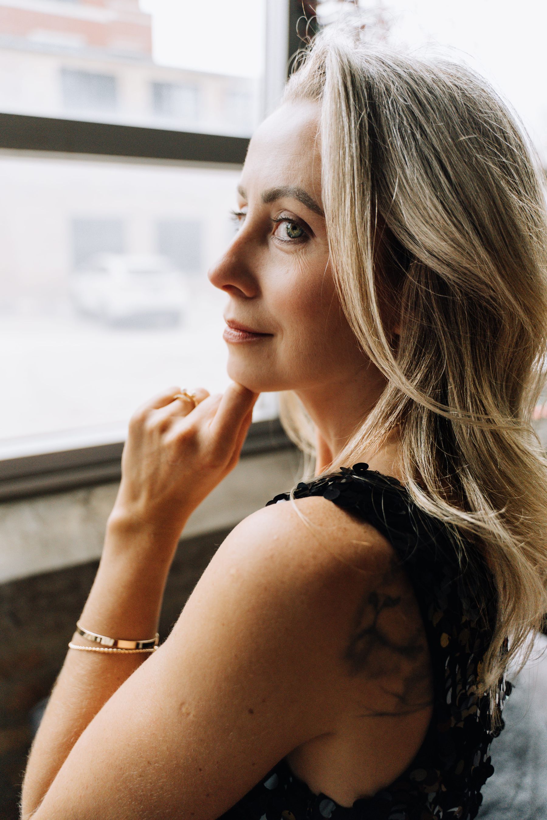 Una mujer de mediana edad reflexiona junto a una ventana